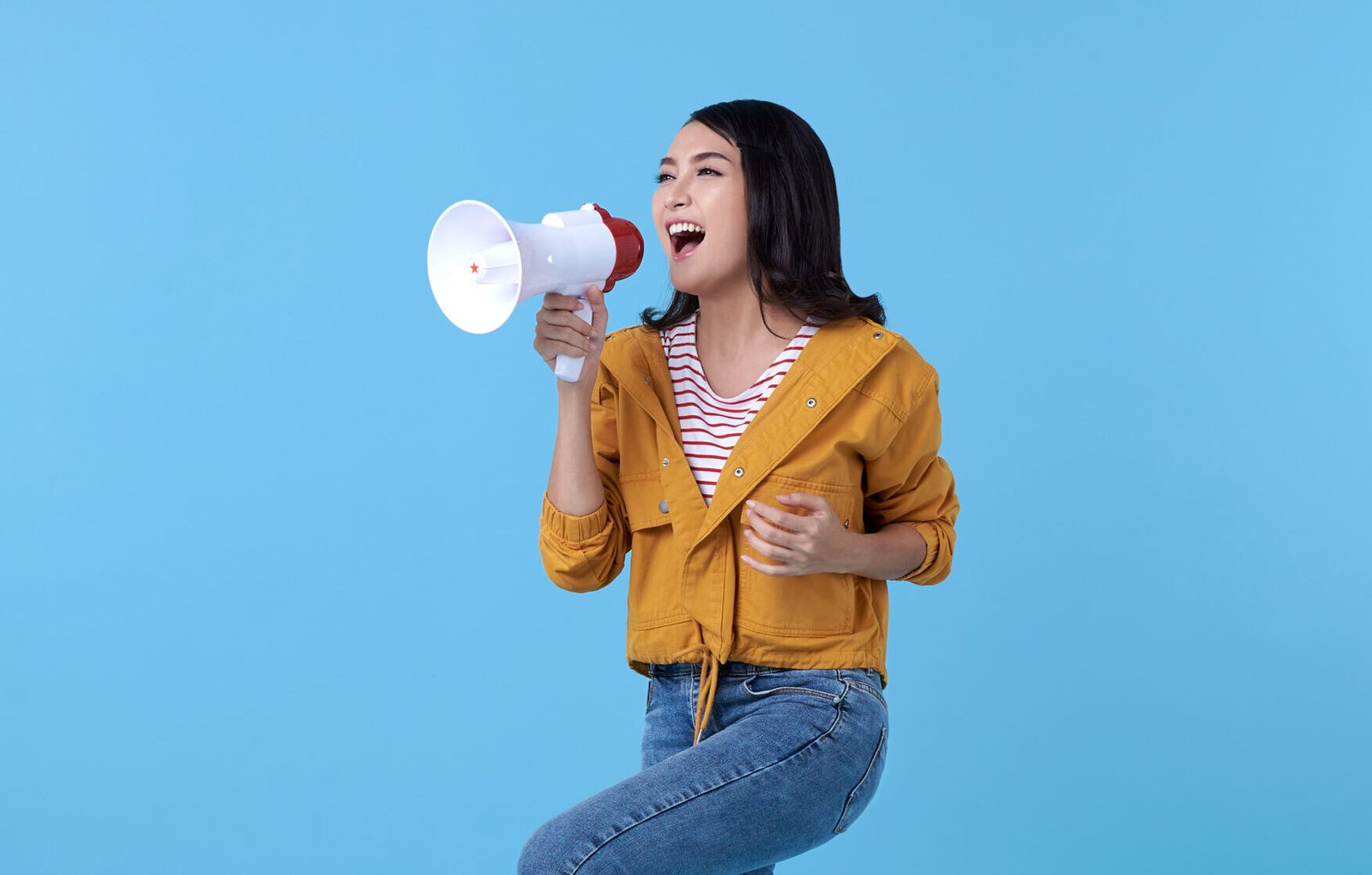 young-asian-woman-shouting-into-megaphone-making-announcement-blue-scaled-e1708947284761